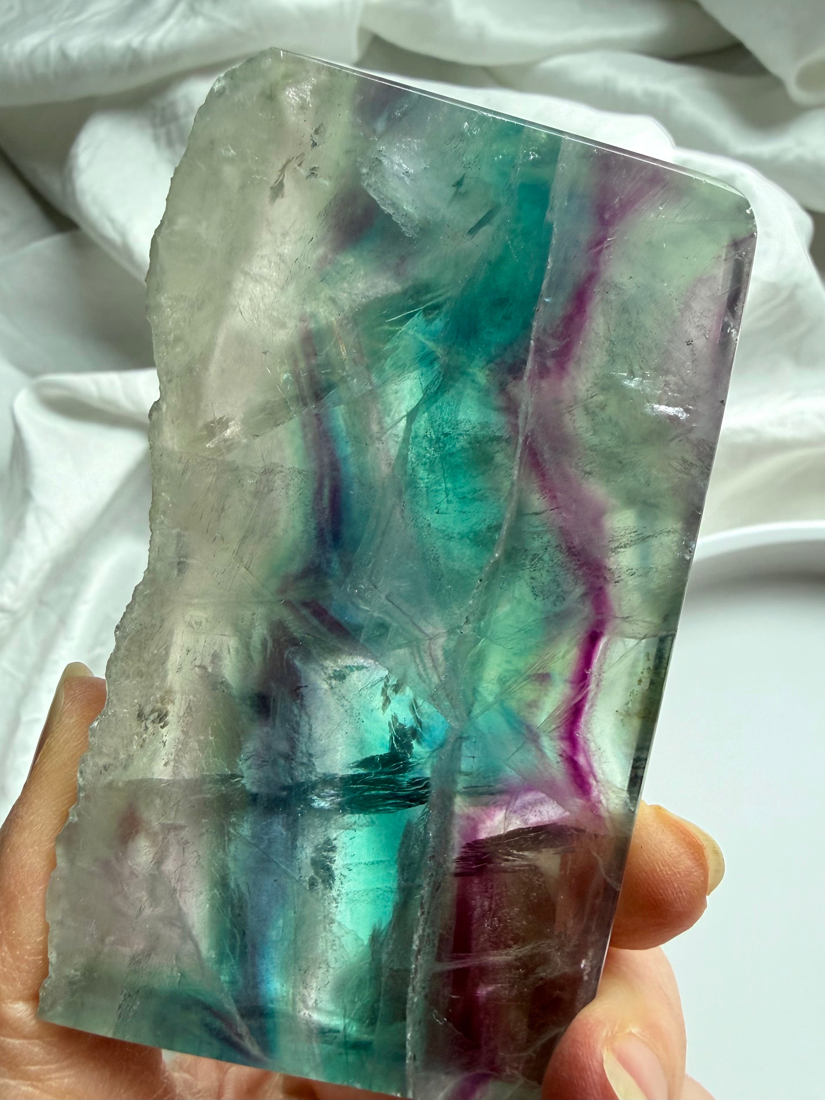 Detail view of one of a kind fluorite slab, smooth polished with one raw crystal edge 