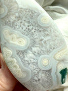 Close-up of Moss Agate flame carving with white orbicular patterns and green inclusions