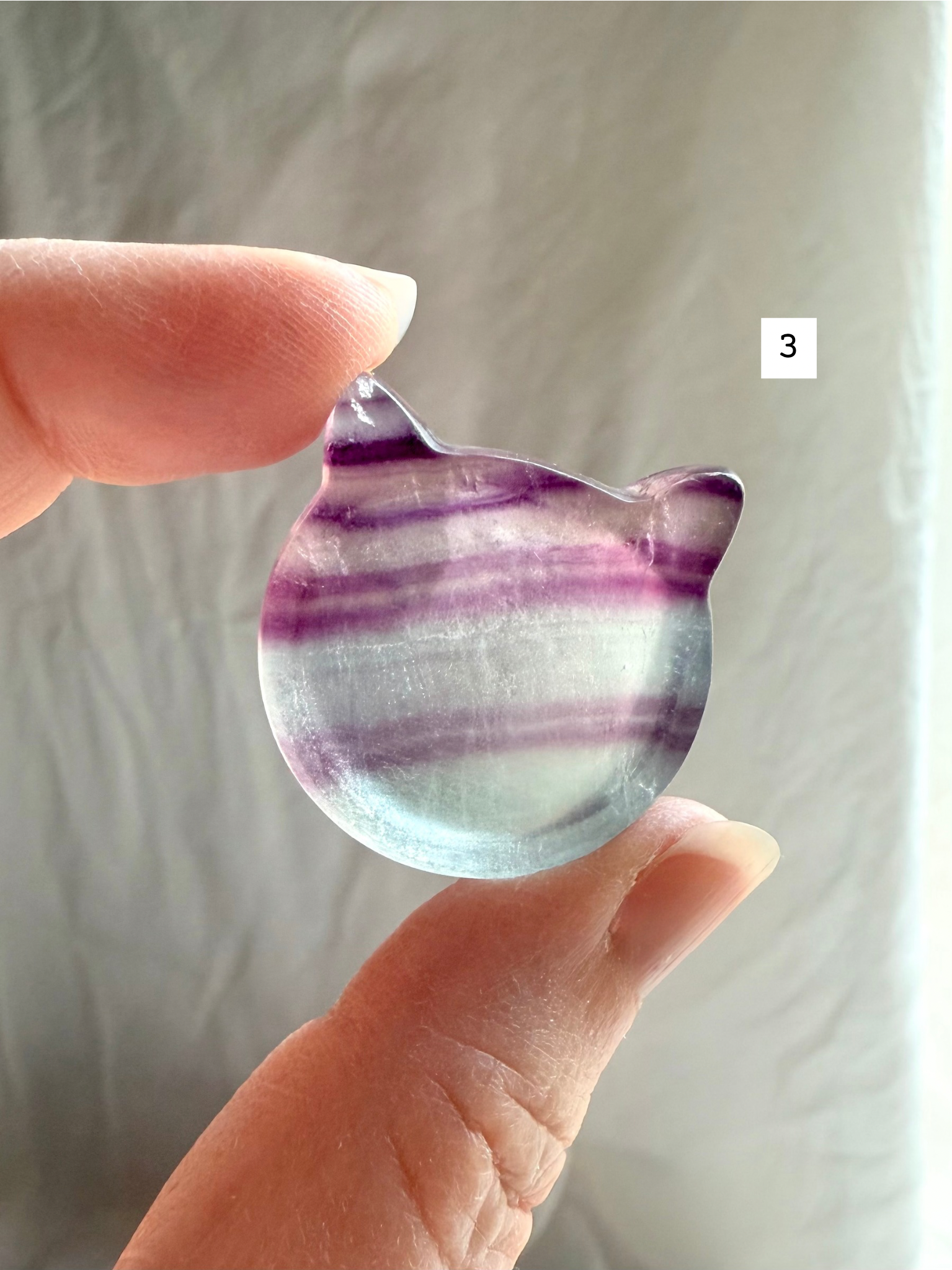 Fluorite cat-shaped crystal bowl held to the light – mini ring dish and jewelry holder