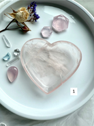 Rose Quartz heart bowl held in hand, showing its translucent pink clarity and etched inner inclusions for heart-healing energy.