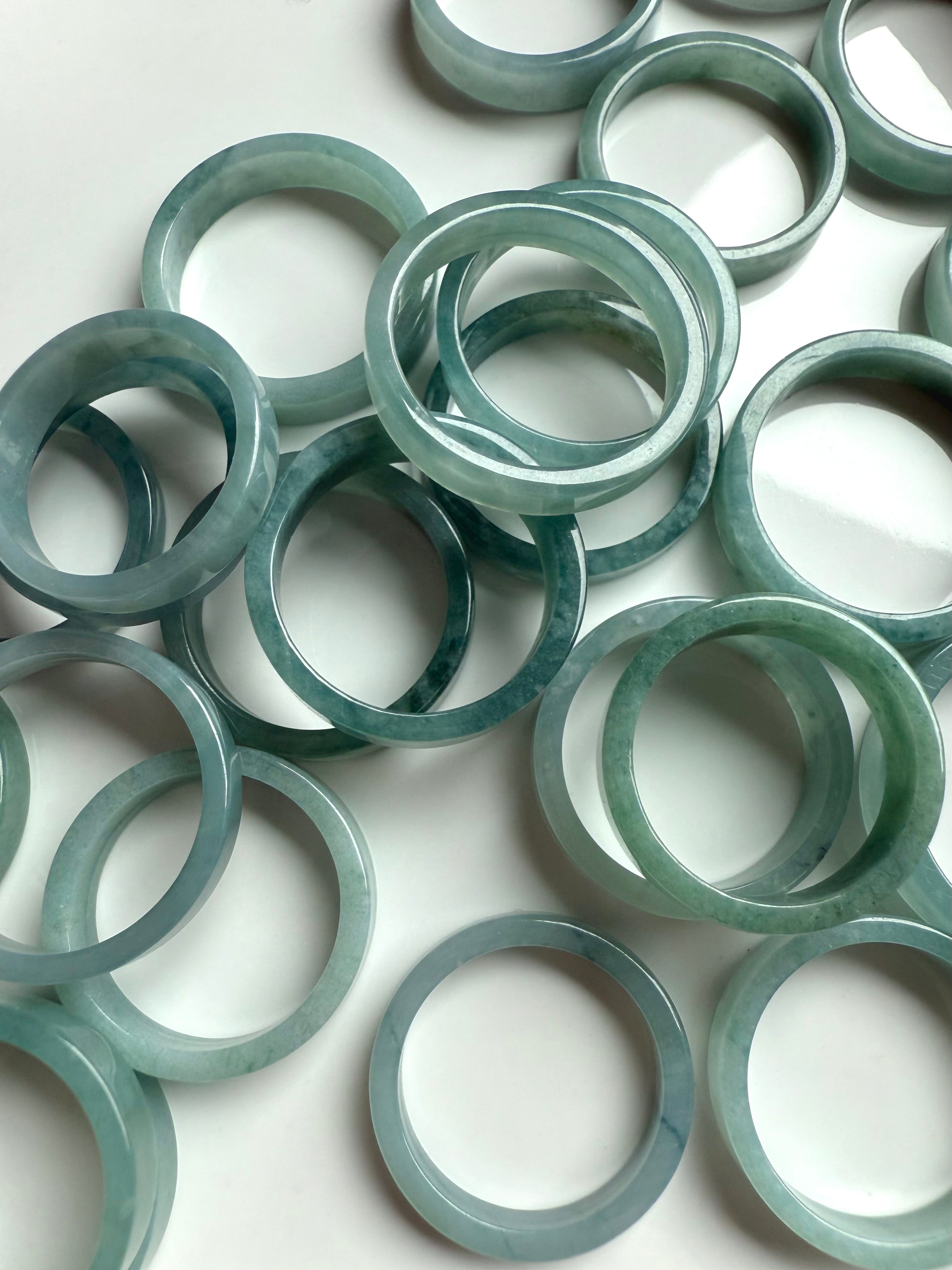 Calming green-blue jadeite crystal rings displayed with peaceful and minimal styling for heart chakra healing