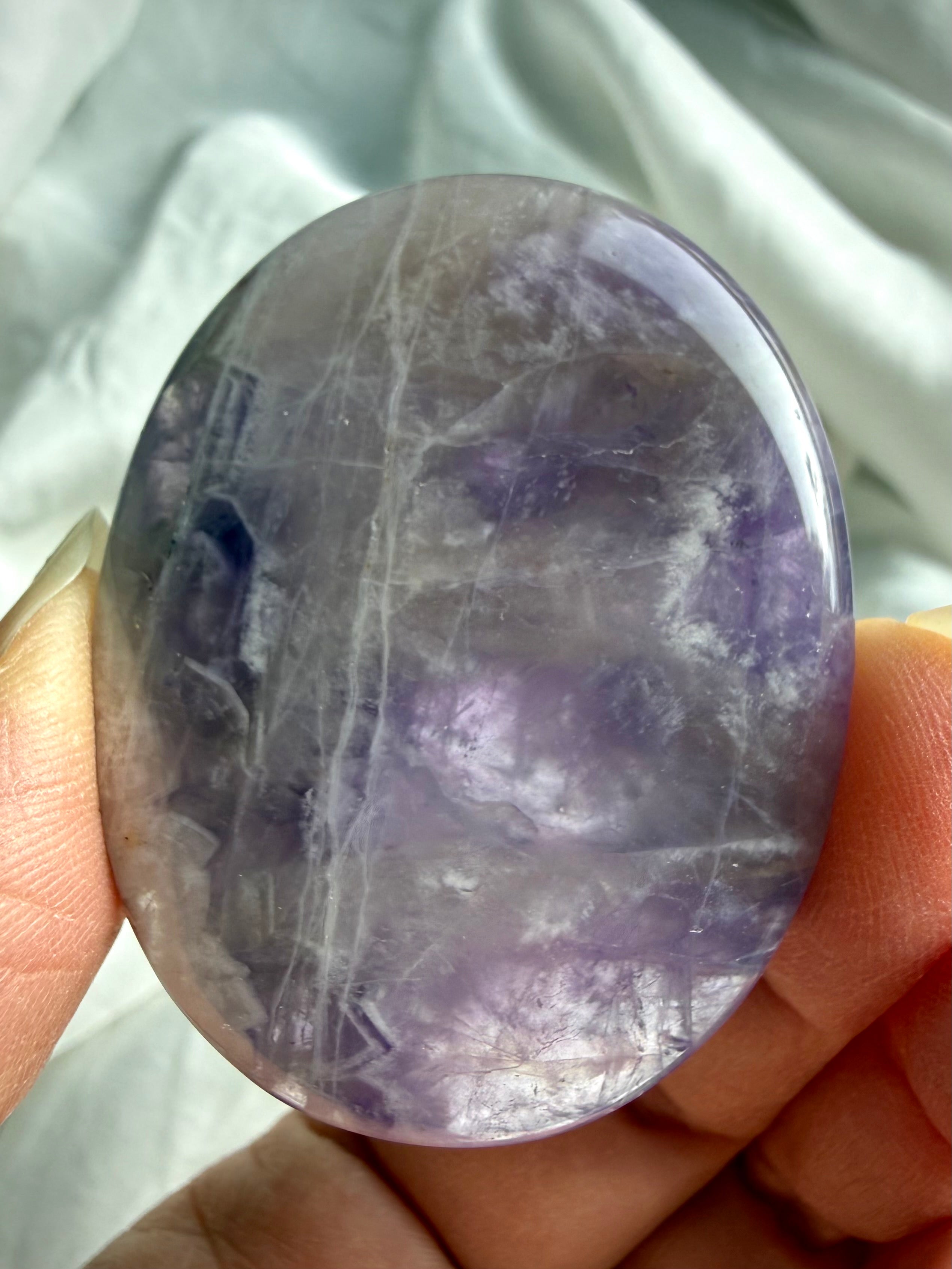 Dream amethyst flat palm stone close up showing natural veining, color variation, and polished flat profile