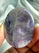 Dream amethyst flat palm stone close up showing natural veining, color variation, and polished flat profile
