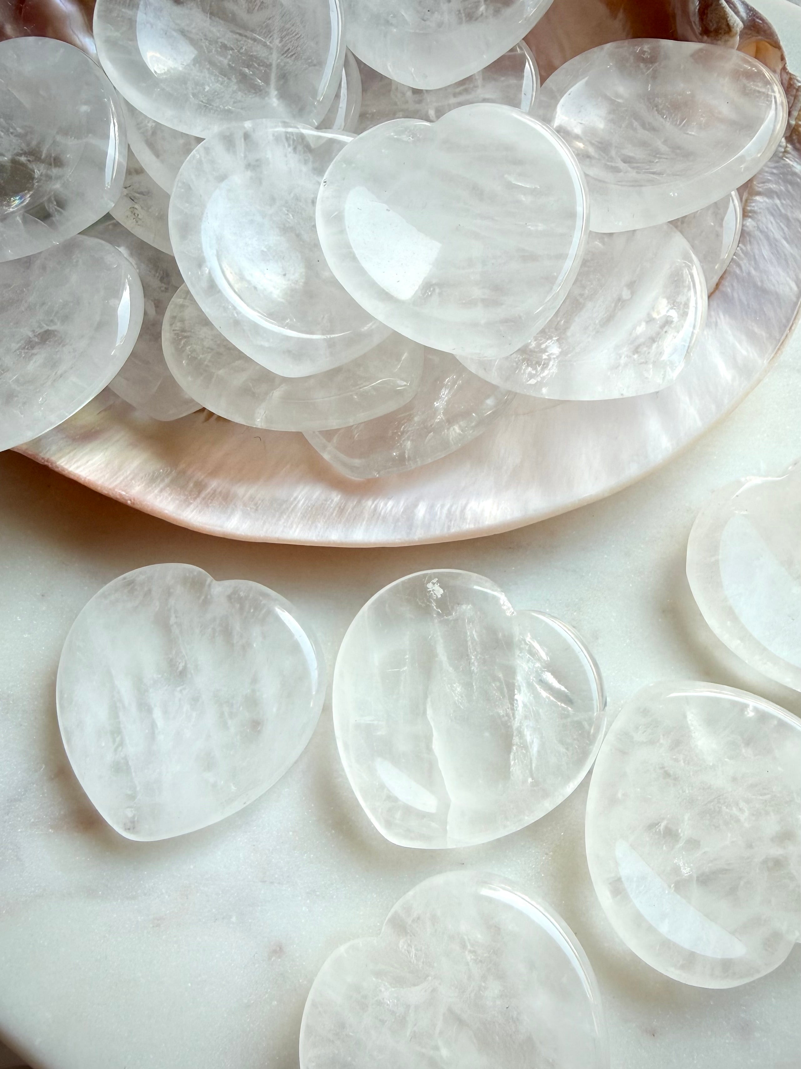 clear quartz heart worry stones close up showing natural inclusions and polished texture