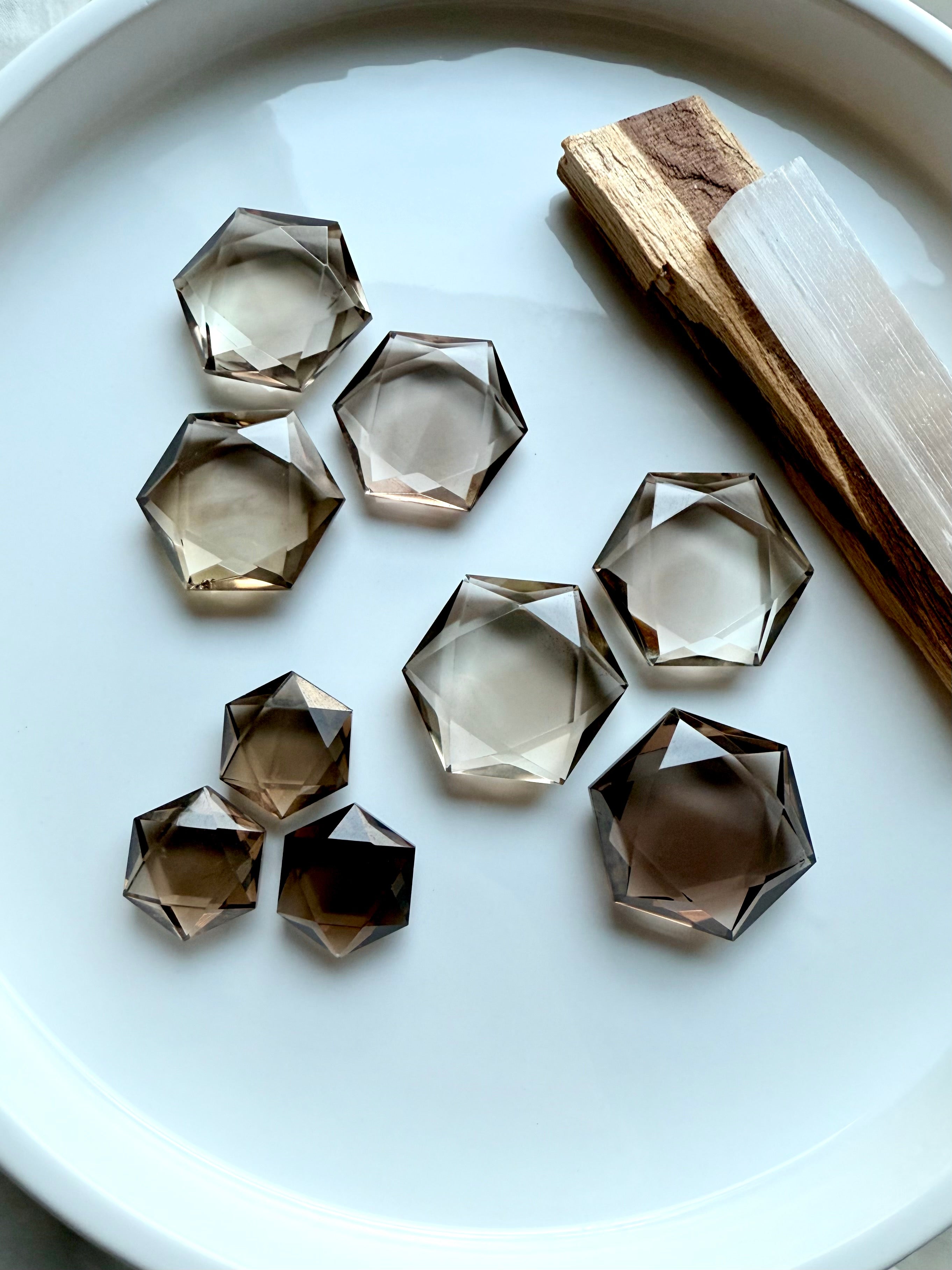Faceted Smoky Quartz Crystal Hexagons grouped into three sizes showing sacred geometric cut, high quality polish, and rich earthy hues