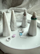 White and gray marble ring holders with faceted sculptural design displayed on vanity tray with rings