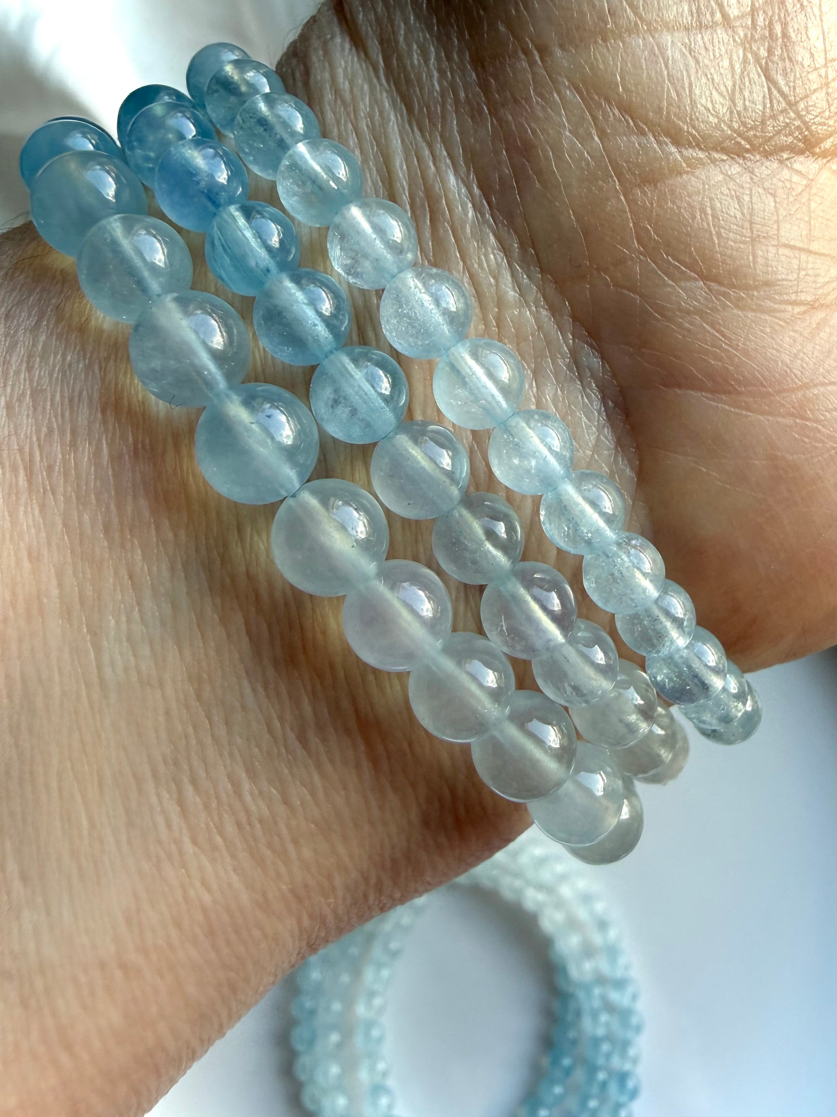 Three Aquamarine ombré crystal bracelets on a wrist – March birthstone and Throat Chakra gemstone jewelry