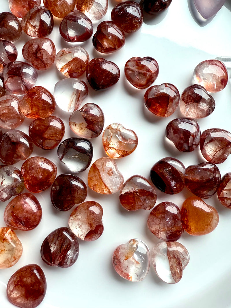 Gemmy Fire Quartz Crystal Hearts shown on a white plate, photographed in natural light