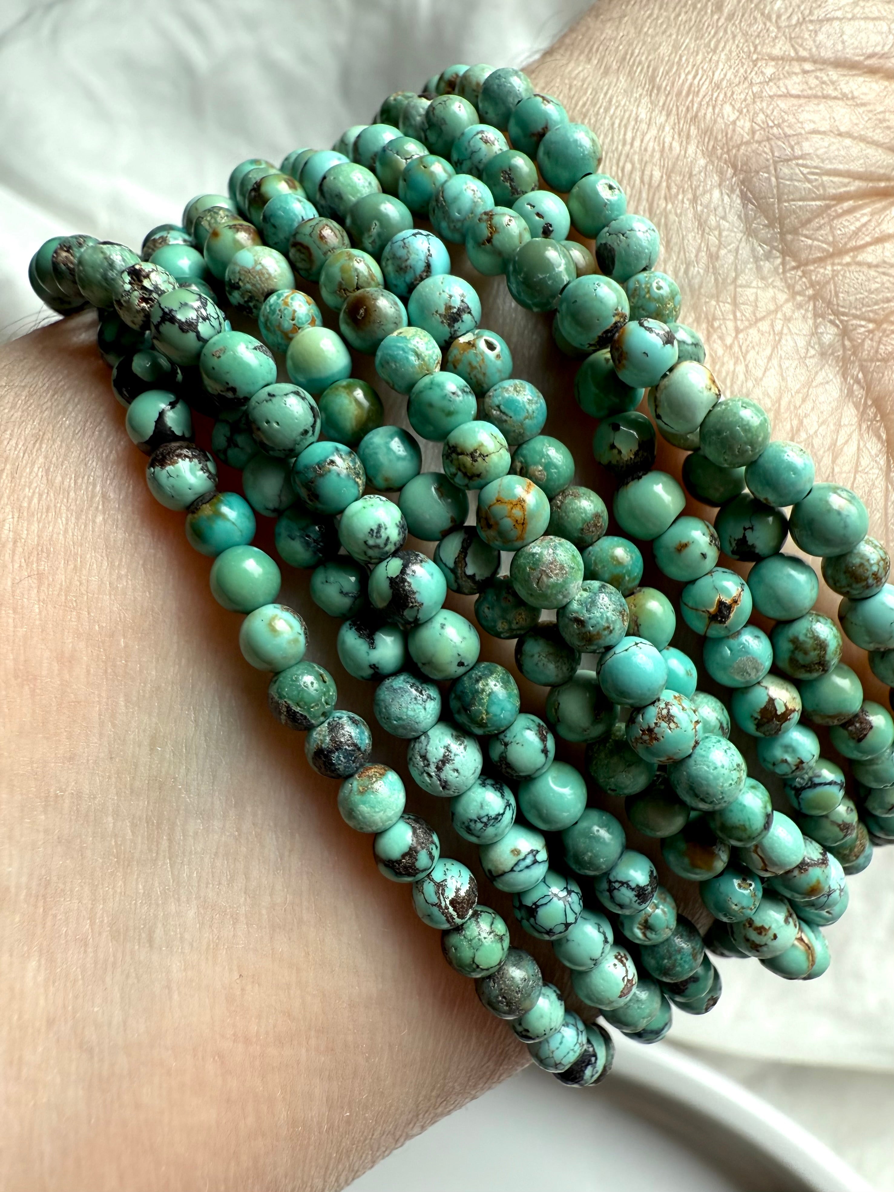 Close-up of stacked Turquoise wrap bracelets showcasing natural blue-green jasper beads with earthy veining and matrix patterns