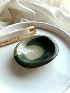 polychrome jasper crystal bowl with teal wave pattern on white tray with selenite and palo santo