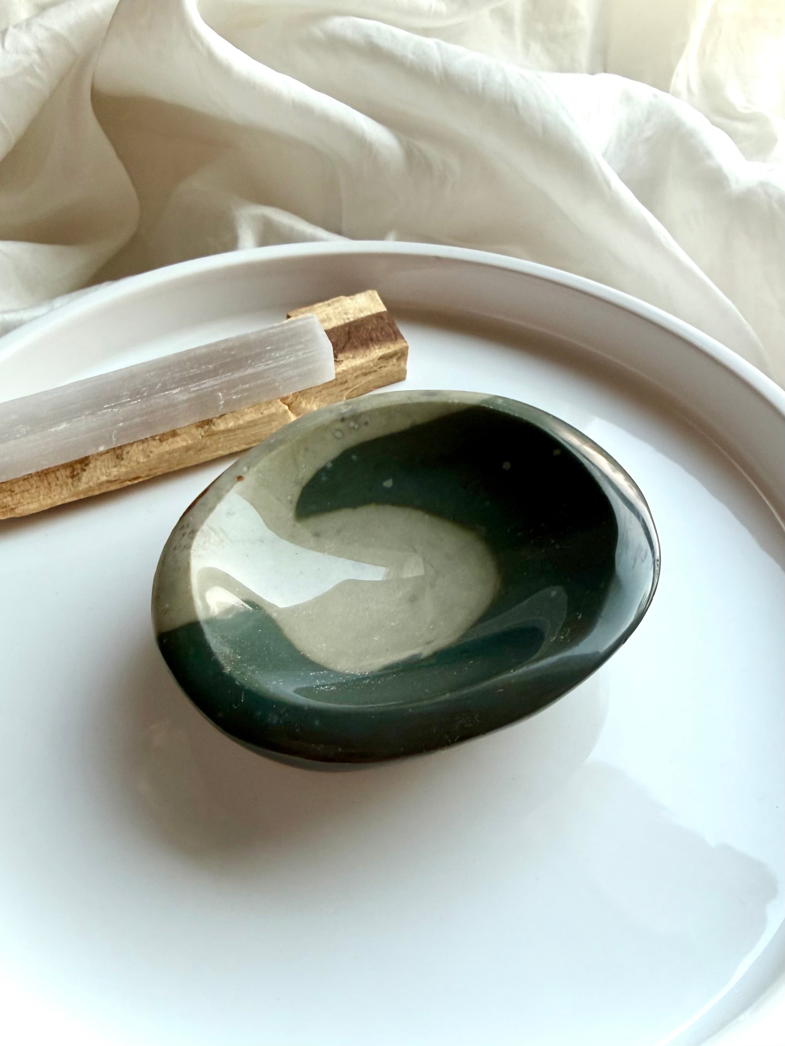 polychrome jasper crystal bowl with teal wave pattern on white tray with selenite and palo santo