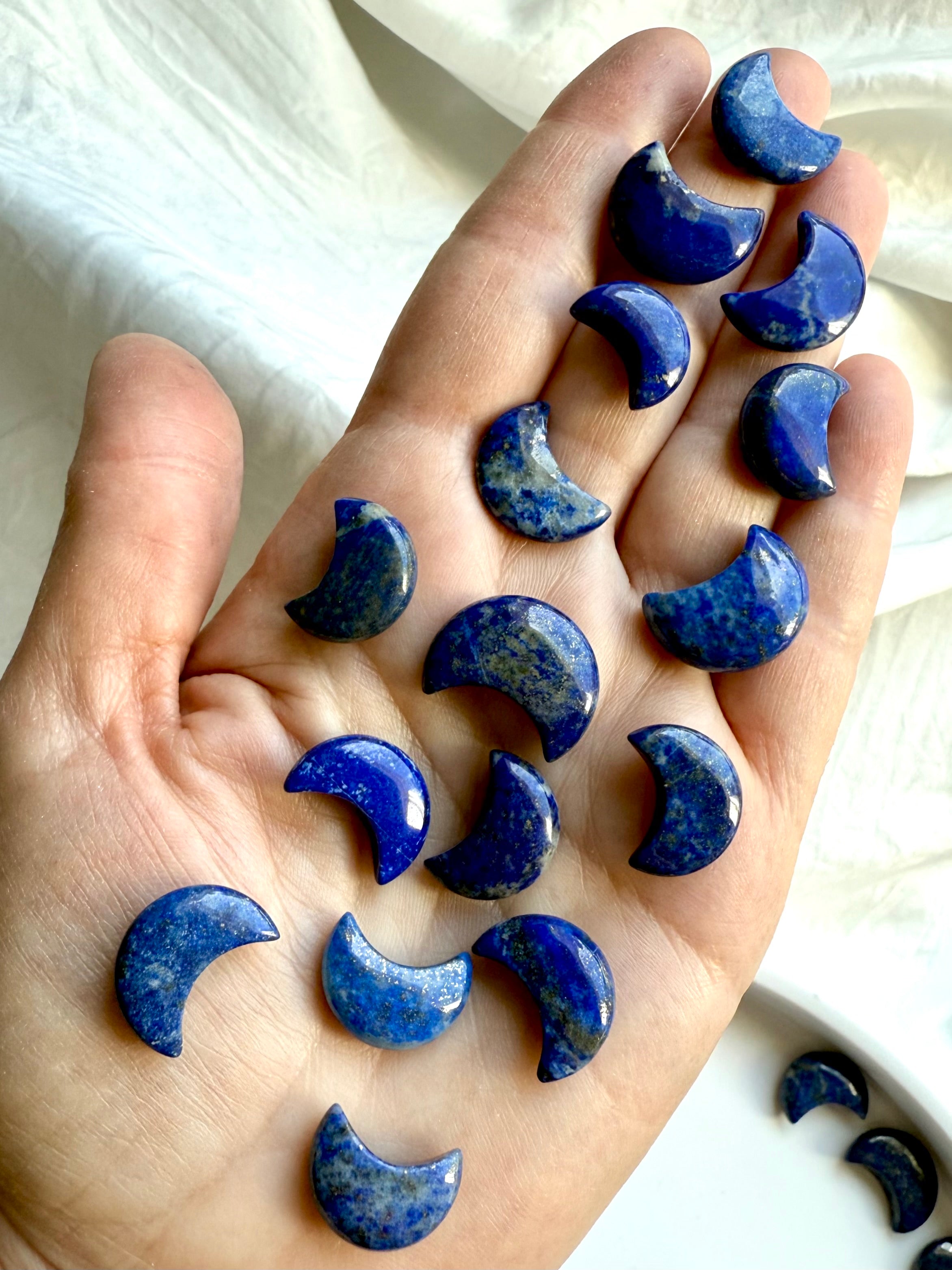Mini Lapis Lazuli moon carvings a woman&#39;s hand for size comparison