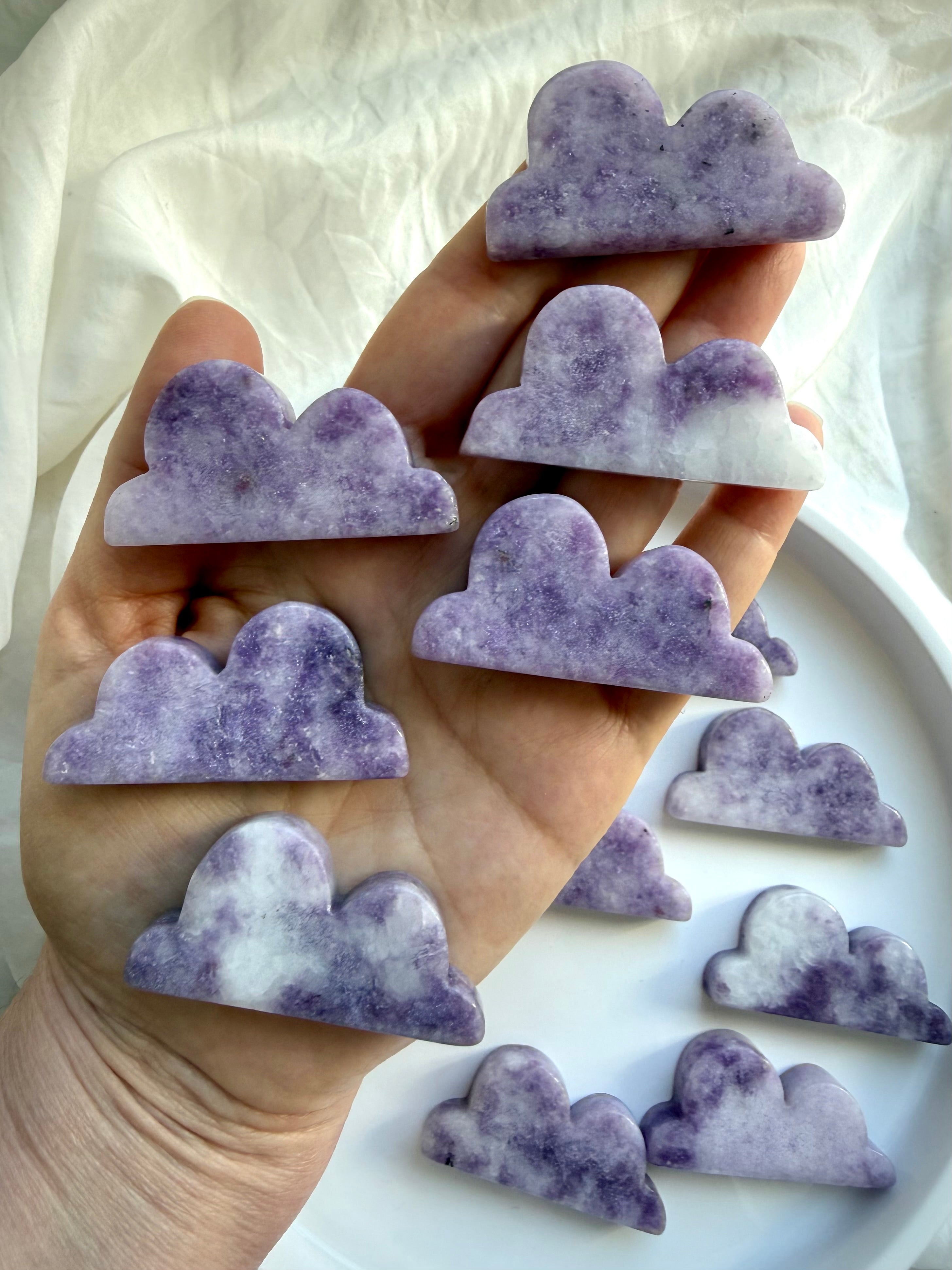 Lepidolite cloud carving in hand showing size scale and soft lavender coloration