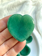 green aventurine heart worry stone held in hand showing smooth polished surface and rich green color