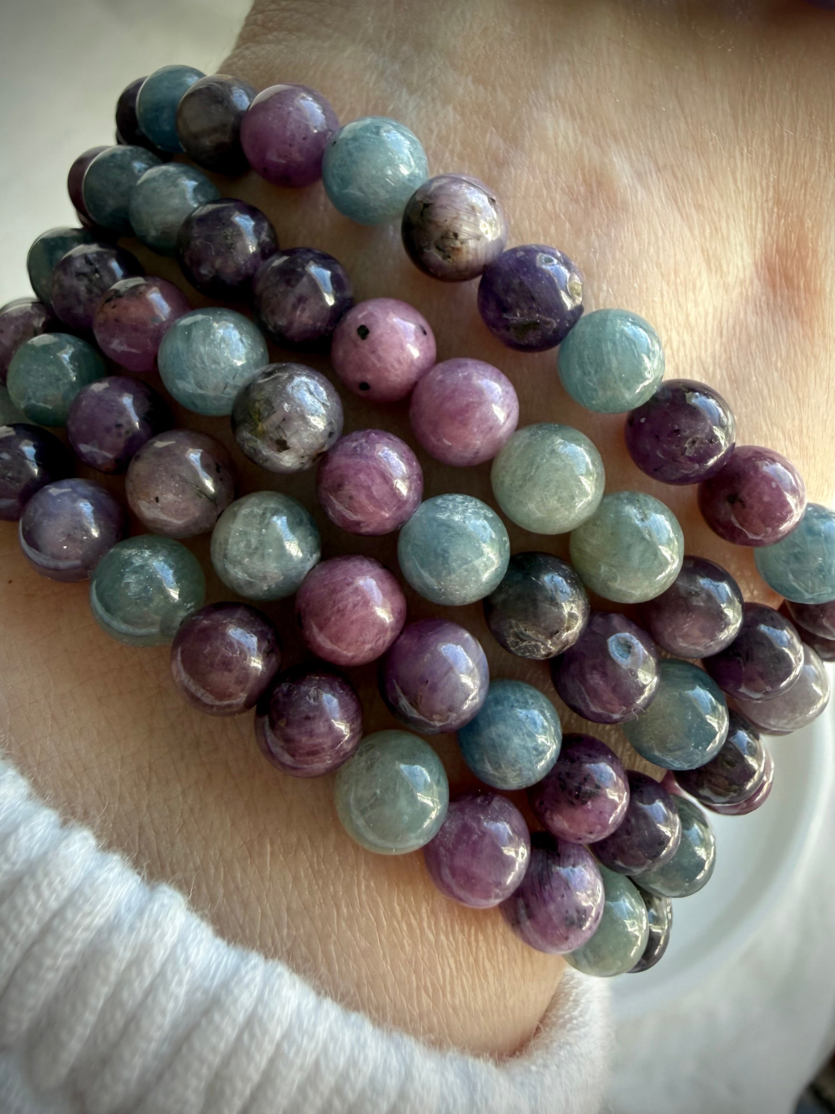 stacked Ruby Sapphire crystal bracelets displaying natural color variation and polished round beads