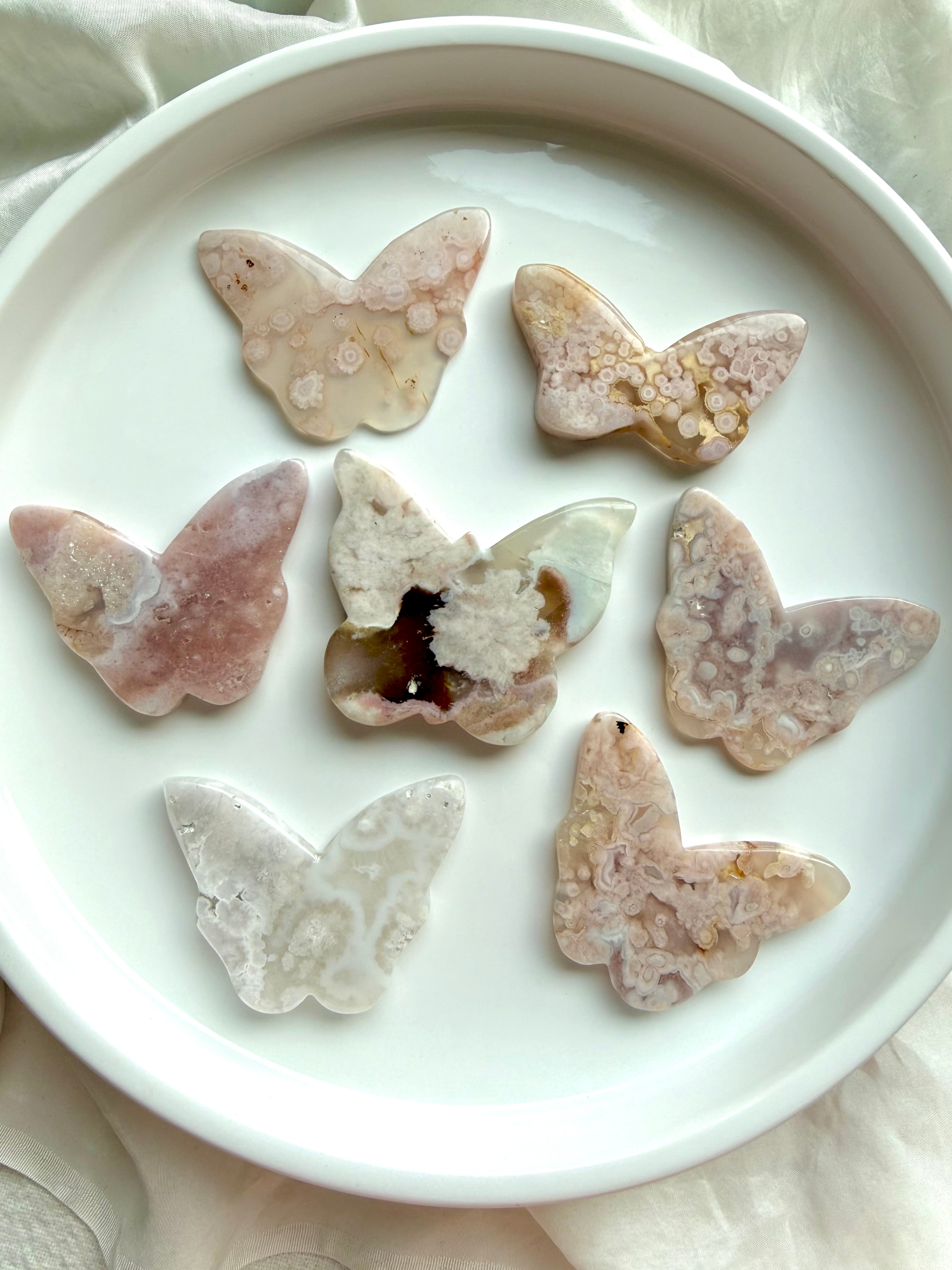 Flower Agate butterfly crystal carvings in soft pink blossom agate on white dish – choose your own butterfly crystal