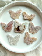 Flower Agate butterfly crystal carvings in soft pink blossom agate on white dish – choose your own butterfly crystal