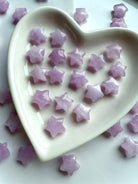 Heart-shaped dish filled with tiny Kunzite mini star carvings in soft lilac hues, heart chakra crystals for divine love and emotional healing.