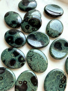 Natural Kambaba Jasper worry stones showing varied green and black orbicular patterns, polished crystals for calm and stress relief