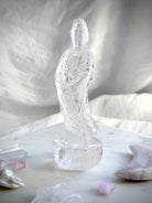Hand-carved Clear Quartz Quan Yin figurine surrounded by crystals and soft altar décor