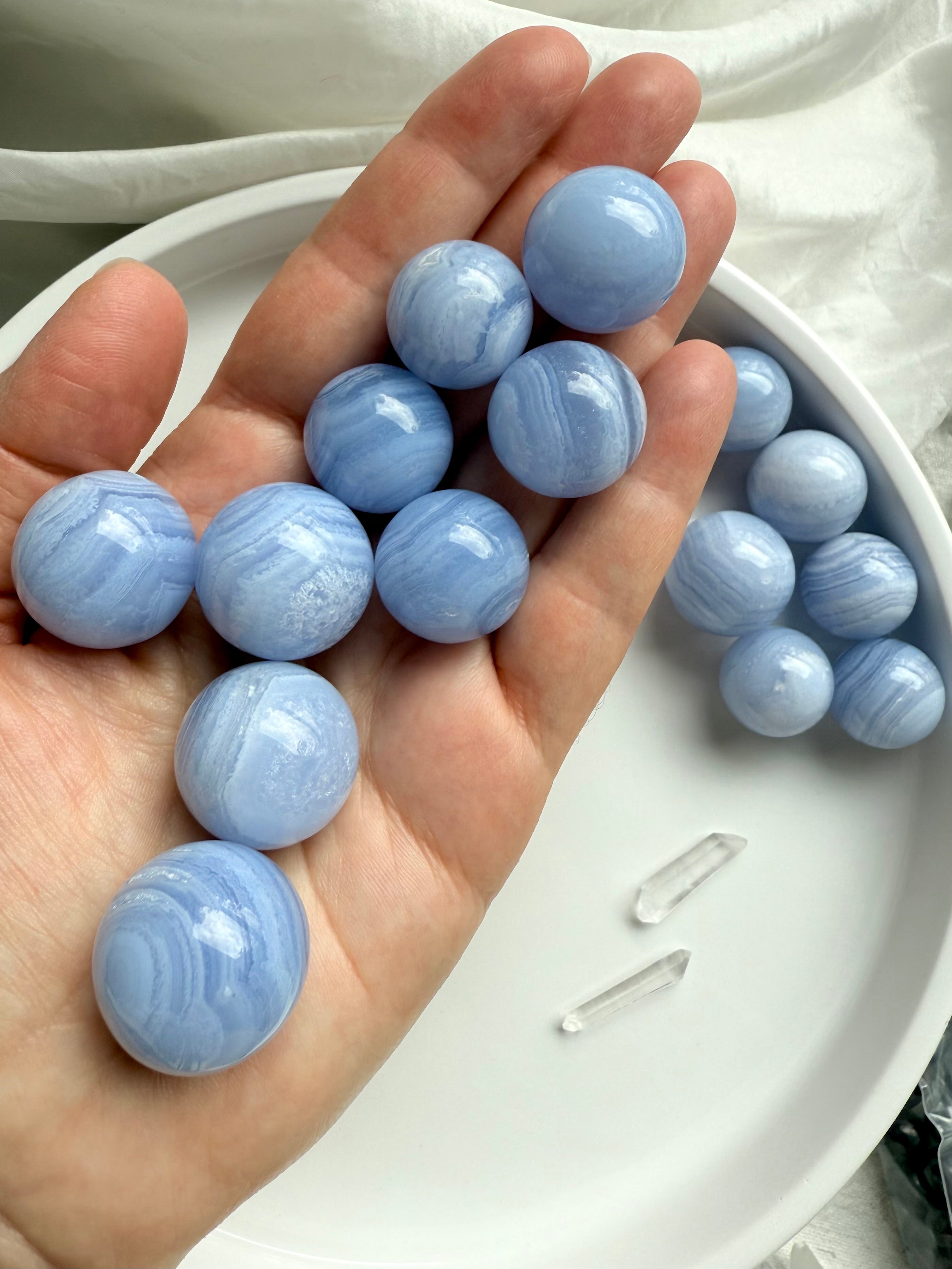 High quality mini Blue Lace Agate Spheres shown on my hand for scale