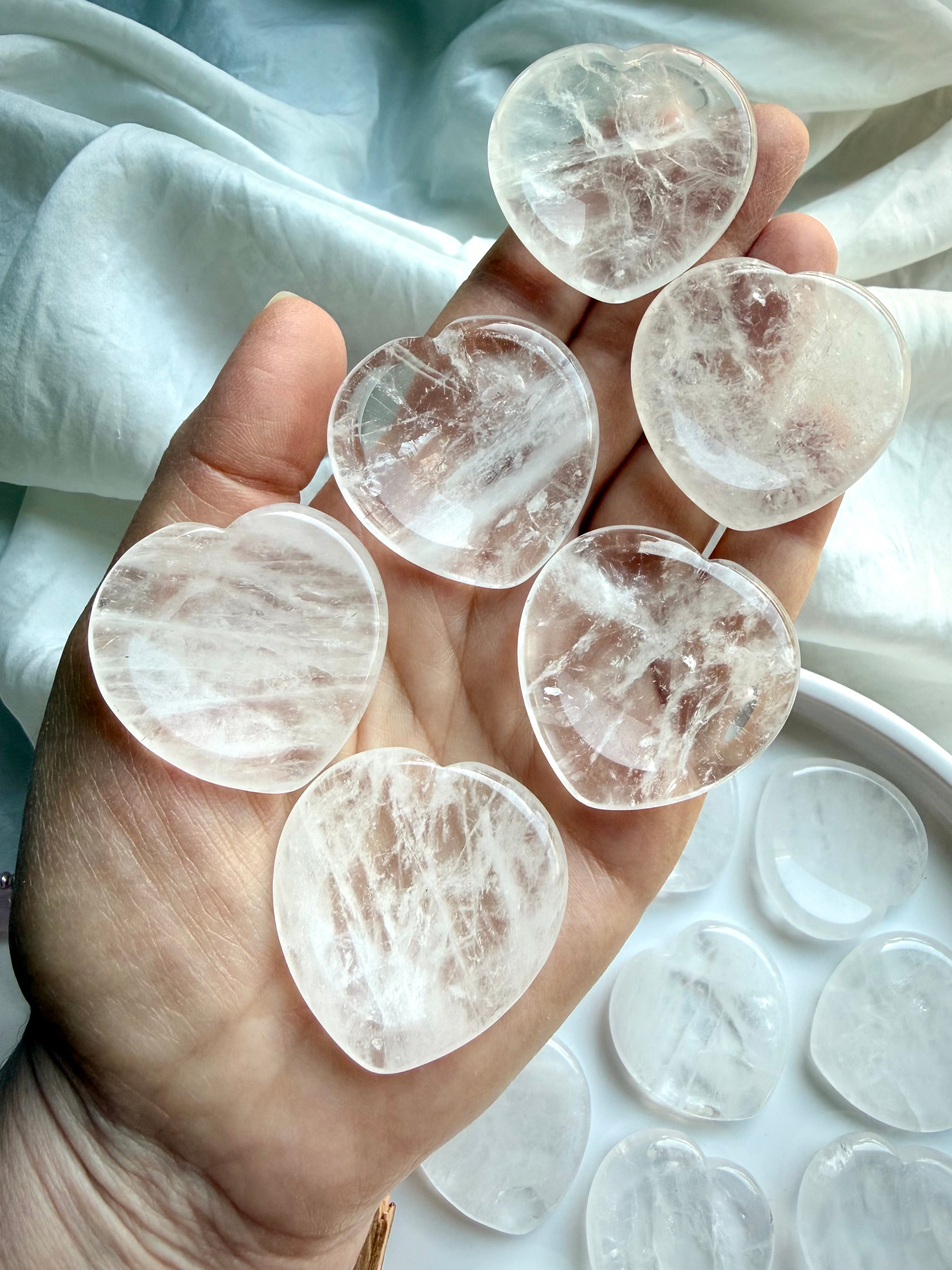 clear quartz hearts in hand for energy amplification clarity and calming support
