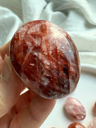 Hematoid Quartz palm stone with red hematite inclusions for grounding, courage, and transformation