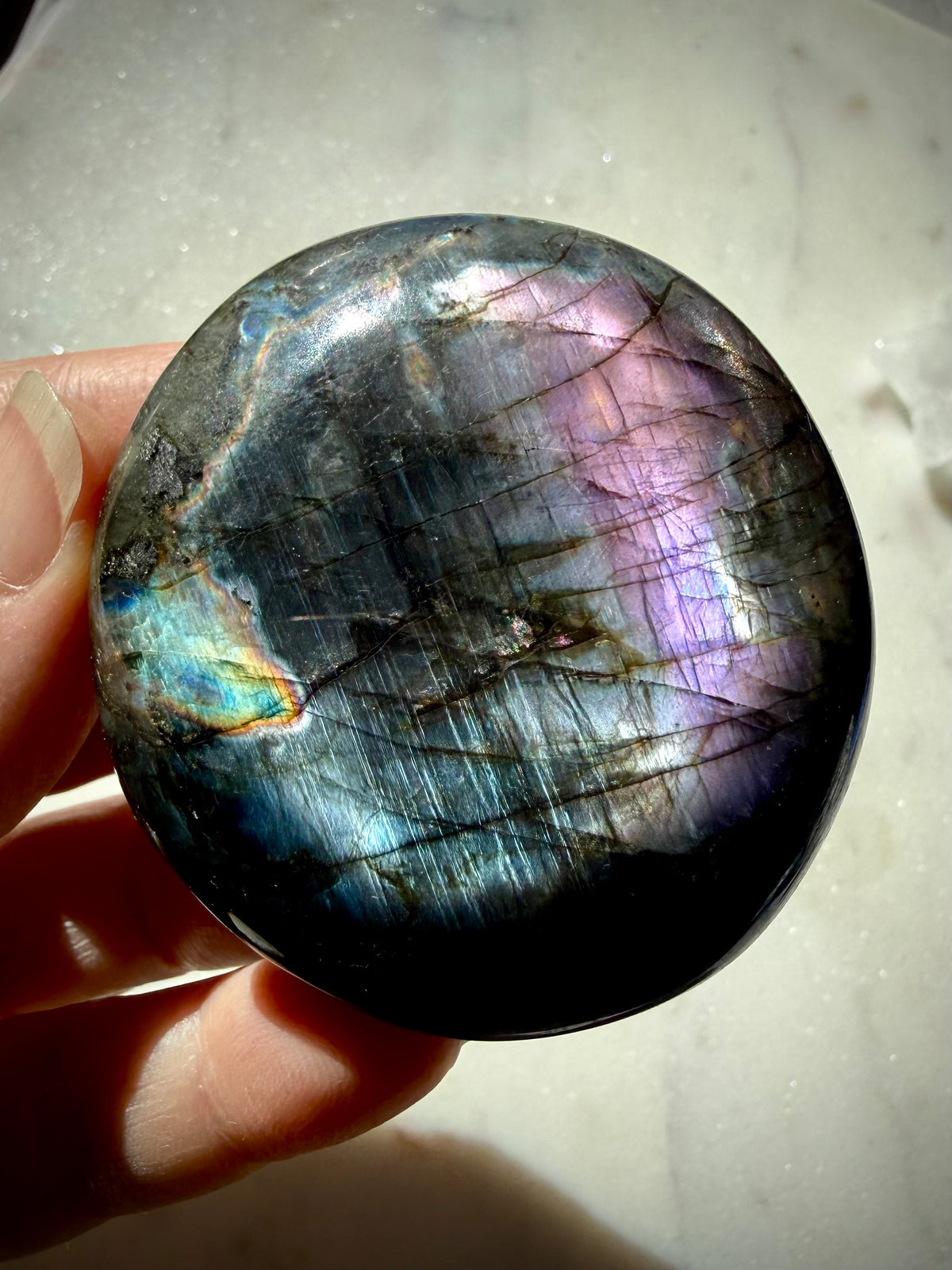 Rainbow flash Labradorite crystal with electric blue, purple and silver labradorescence against natural dark silver matrix