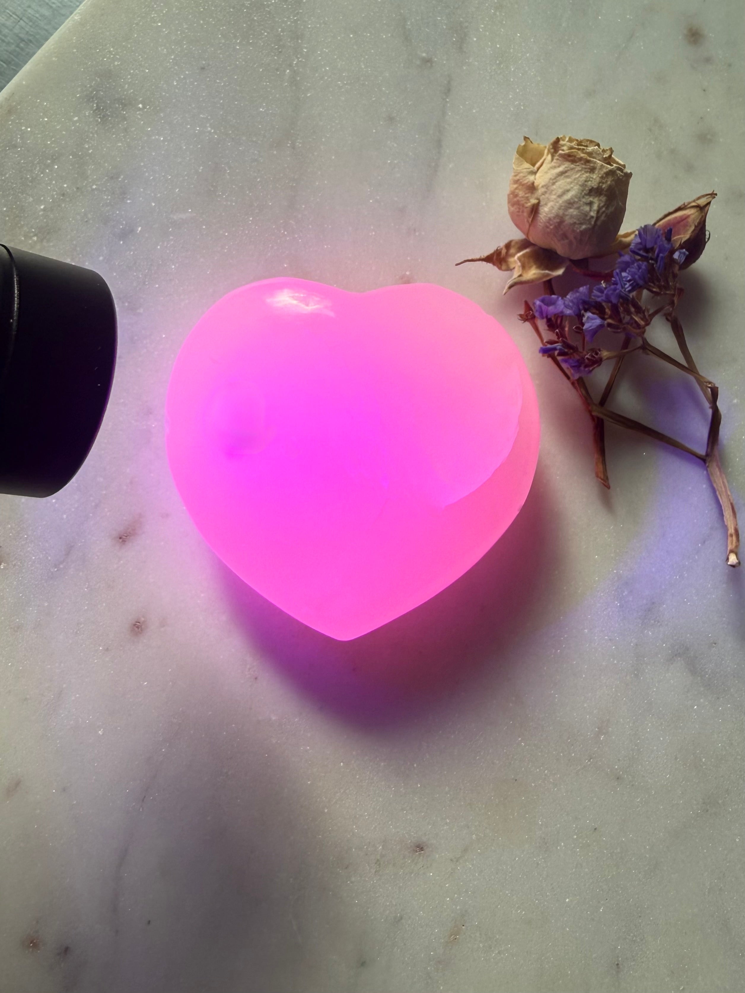 UV fluorescent Mangano Calcite heart crystal from Pakistan glowing vivid pink under UV light 