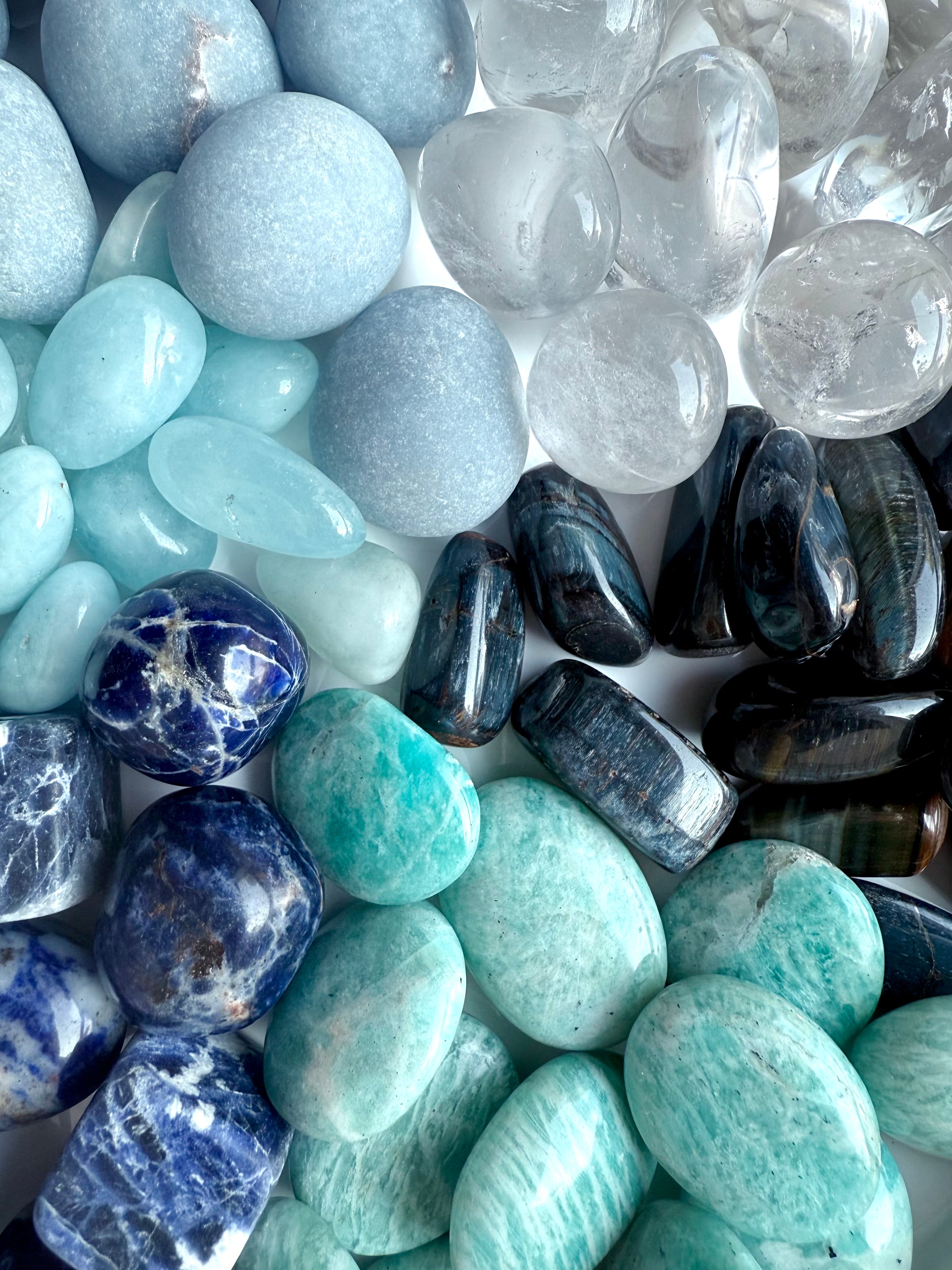Close-up of throat chakra crystal set showing Angelite, Sodalite, Amazonite, Aquamarine, Blue Tiger’s Eye, and Clear Quartz