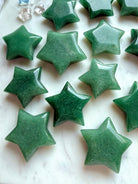 Natural Green Aventurine stars showing varied green tones, polished surfaces, and gently beveled five-point shapes