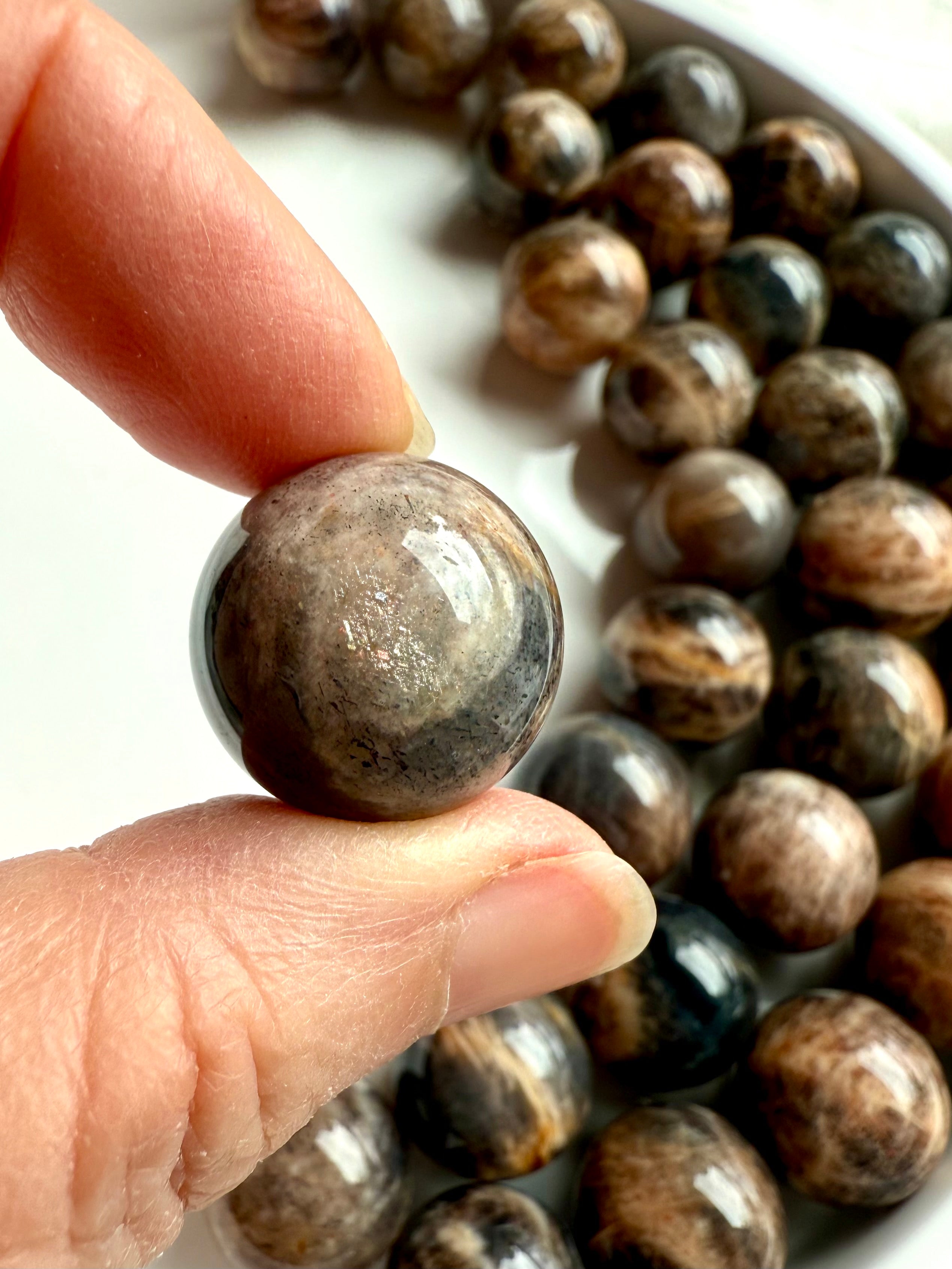 Closeup of Mini Black Moonstone sphere showing lattice sunstone inclusions and golden shimmer