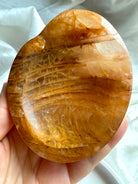Golden Healer bowl held in hand for scale – crystal charging dish for altar or sacred space