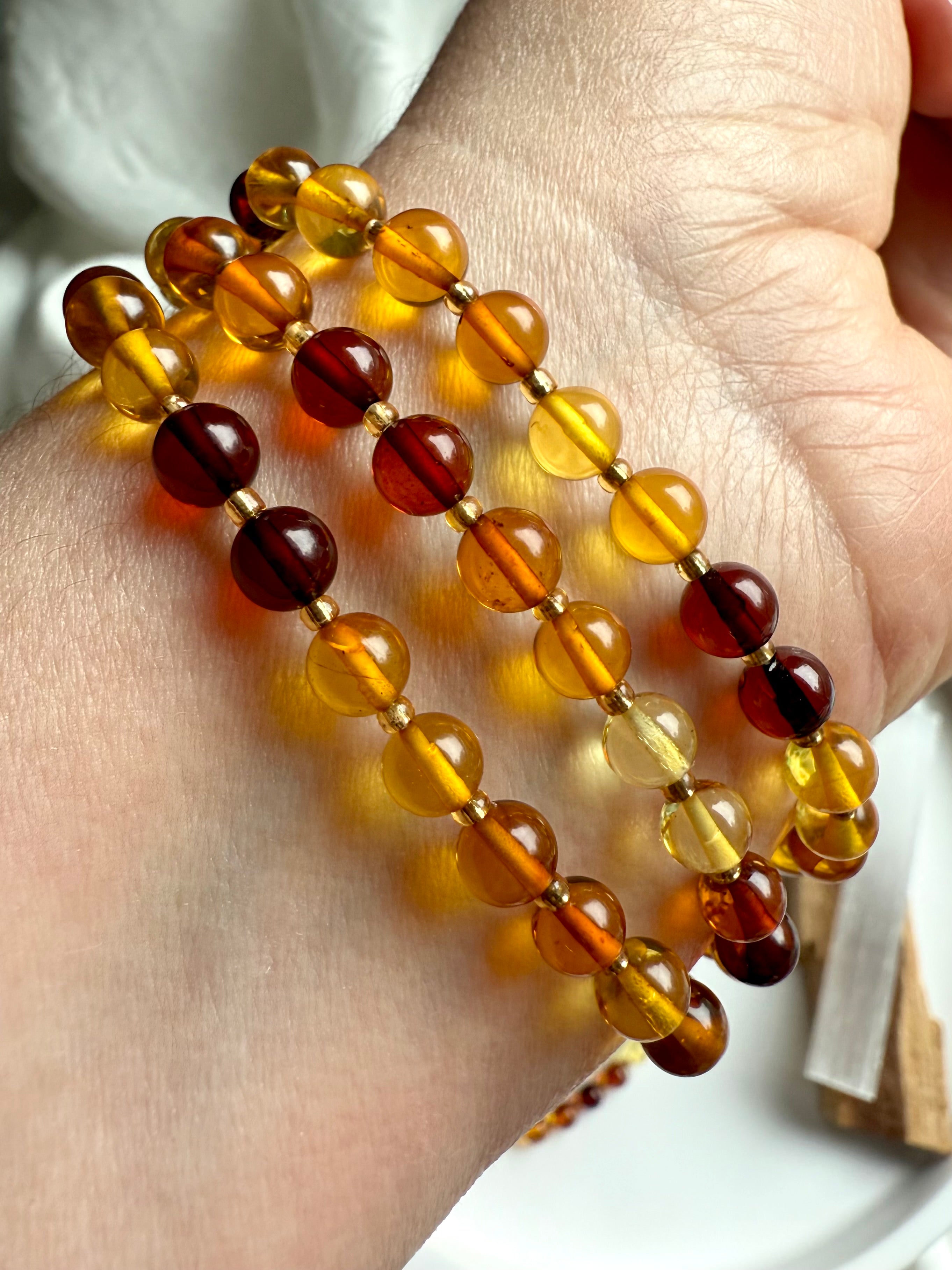 Stack of three polished golden amber bead bracelets – warm healing crystal for solar plexus chakra support