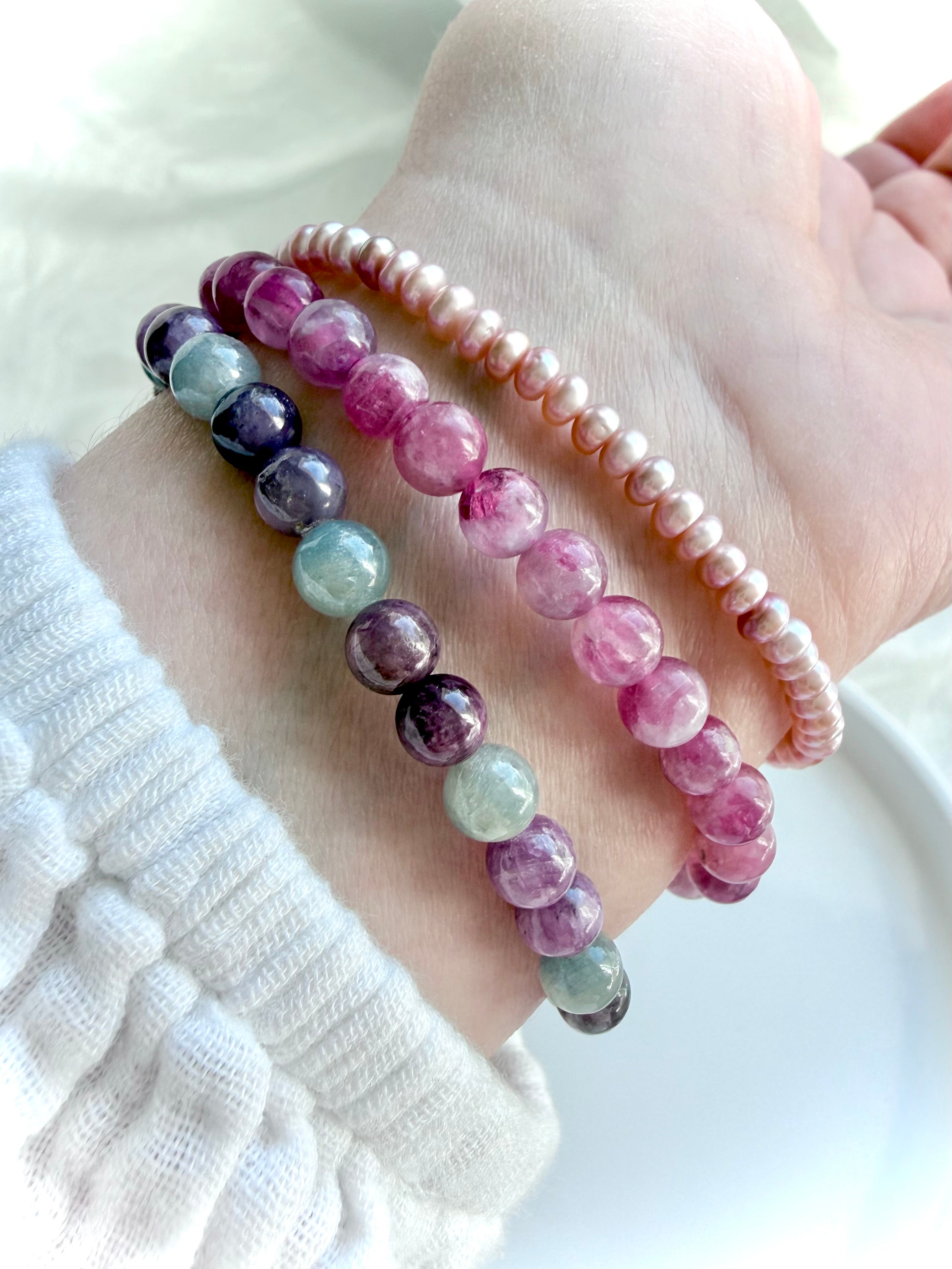 Pink Tourmaline bracelet layered with Ruby Sapphire and Pink Pearl bracelets, highlighting complementary crystal bracelet styling