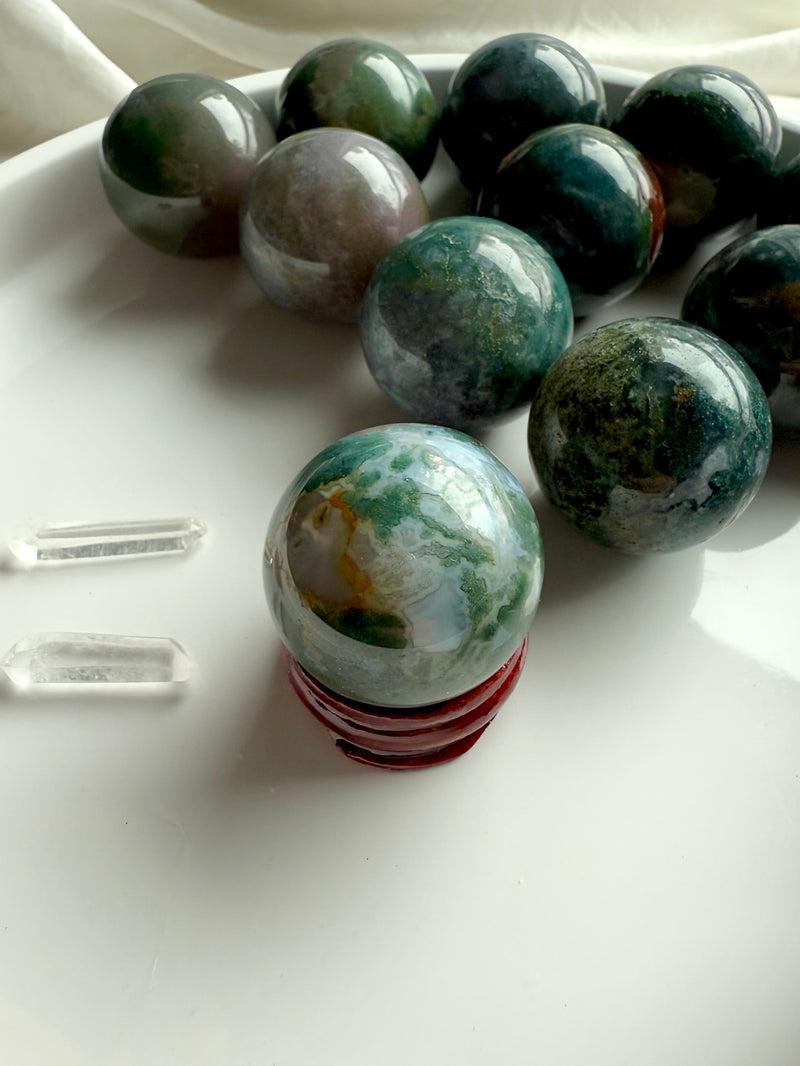 Colorful moss agate mini spheres shown on the simple wood stand option available in the dropdown