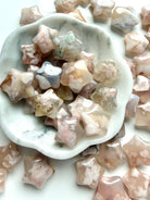 Mini Flower Agate star carvings in soft pink and cream tones displayed in a marble bowl
