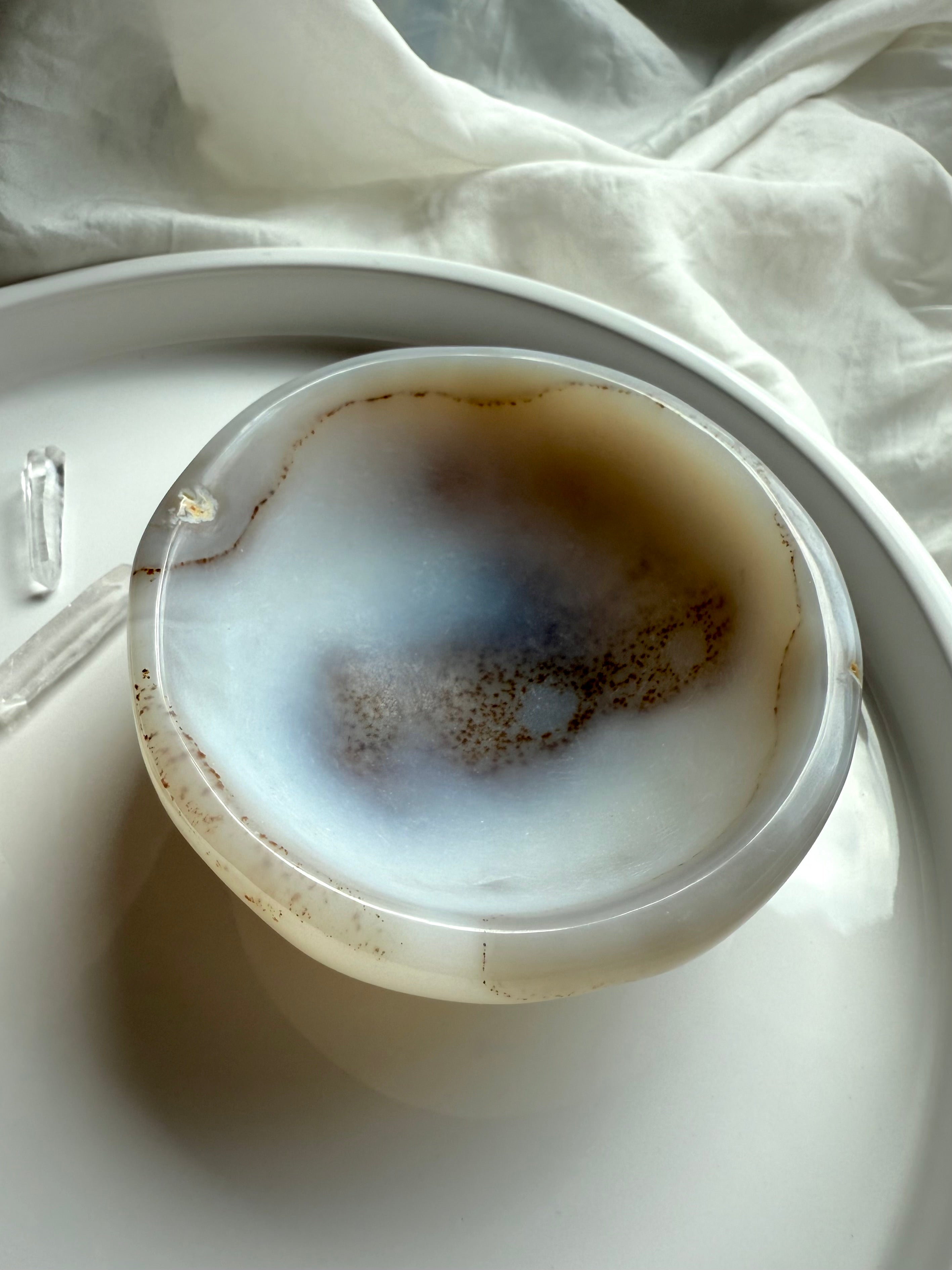 Polished White Agate bowl with smooth edges and natural patterns, gemstone offering dish for calm and grounding rituals