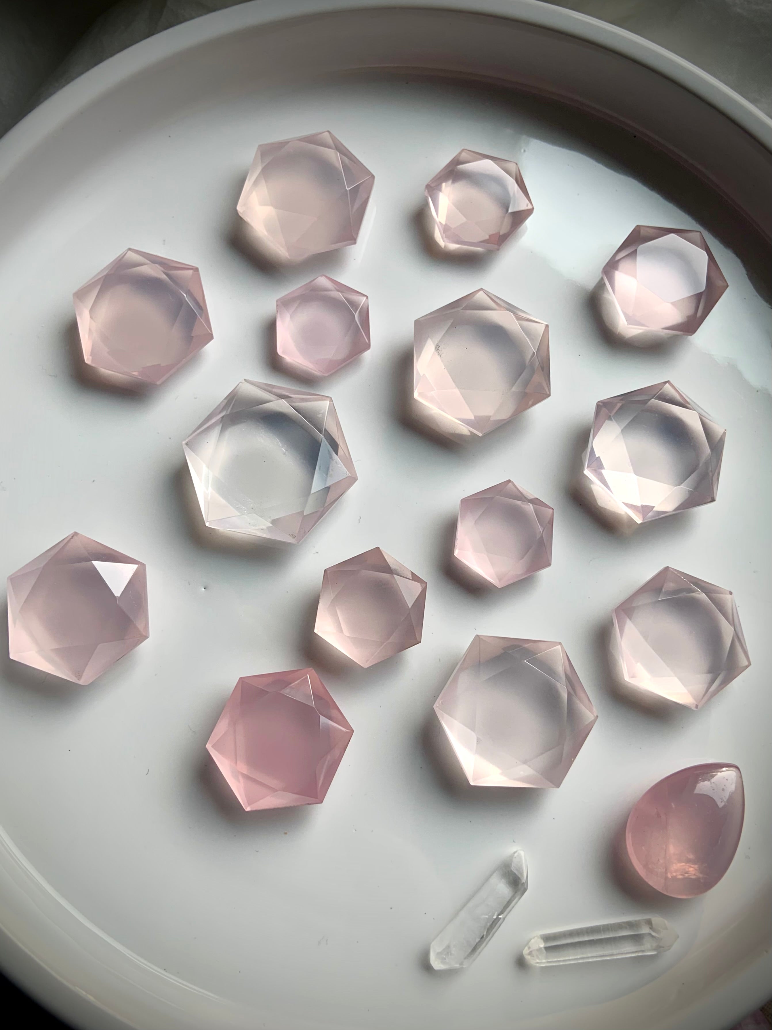 Closeup of faceted pink Rose Quartz hexagon crystals with clear quartz points, luminous Heart Chakra stones for emotional healing and clarity