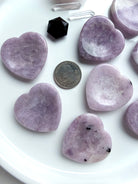 Lepidolite heart worry stones with US quarter for size comparison on white tray