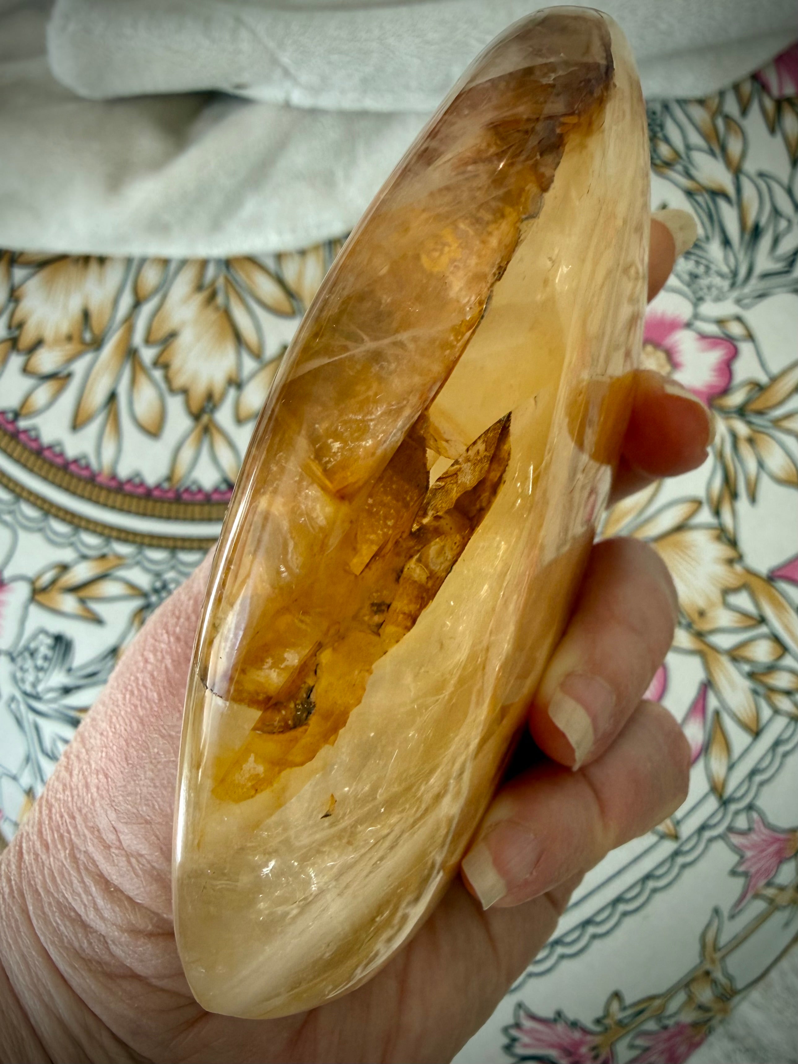 Side view of polished Golden Healer Quartz display crystal with luminous amber-gold tones and sculptural form