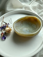 Side view of beige agate crystal bowl on white tray – hand-carved gemstone offering dish