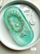 Green Fluorite crystal bowl styled as a jewelry dish with bracelet, ring, and small crystals