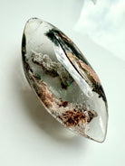 Garden Quartz marquise-shaped lens with phantom lines in earthy green, gold, rust tones, and a rainbow inclusion