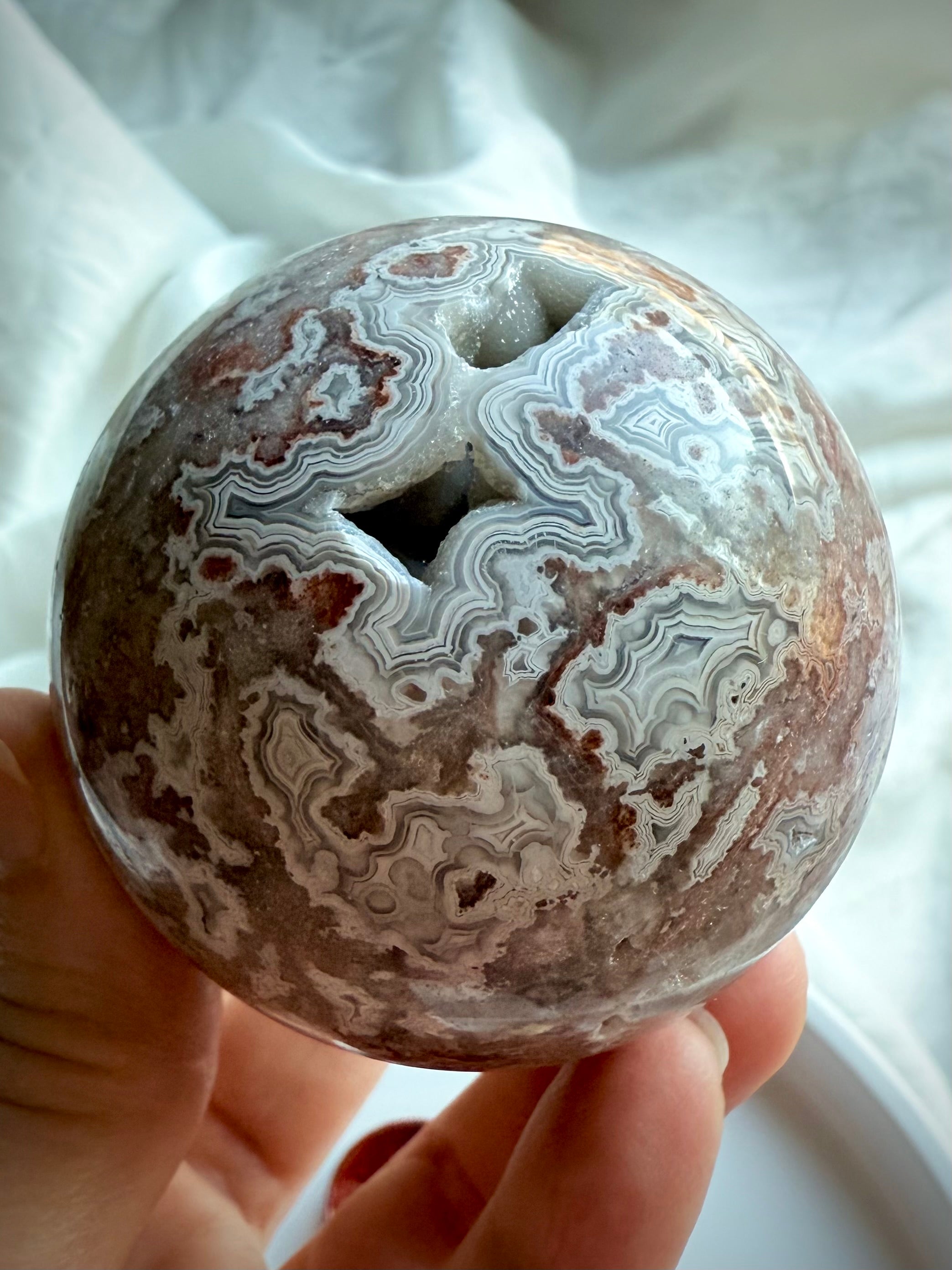 Earthy Crazy Lace Agate sphere with flowing patterns in red, gray, and white agate for energetic alignment 