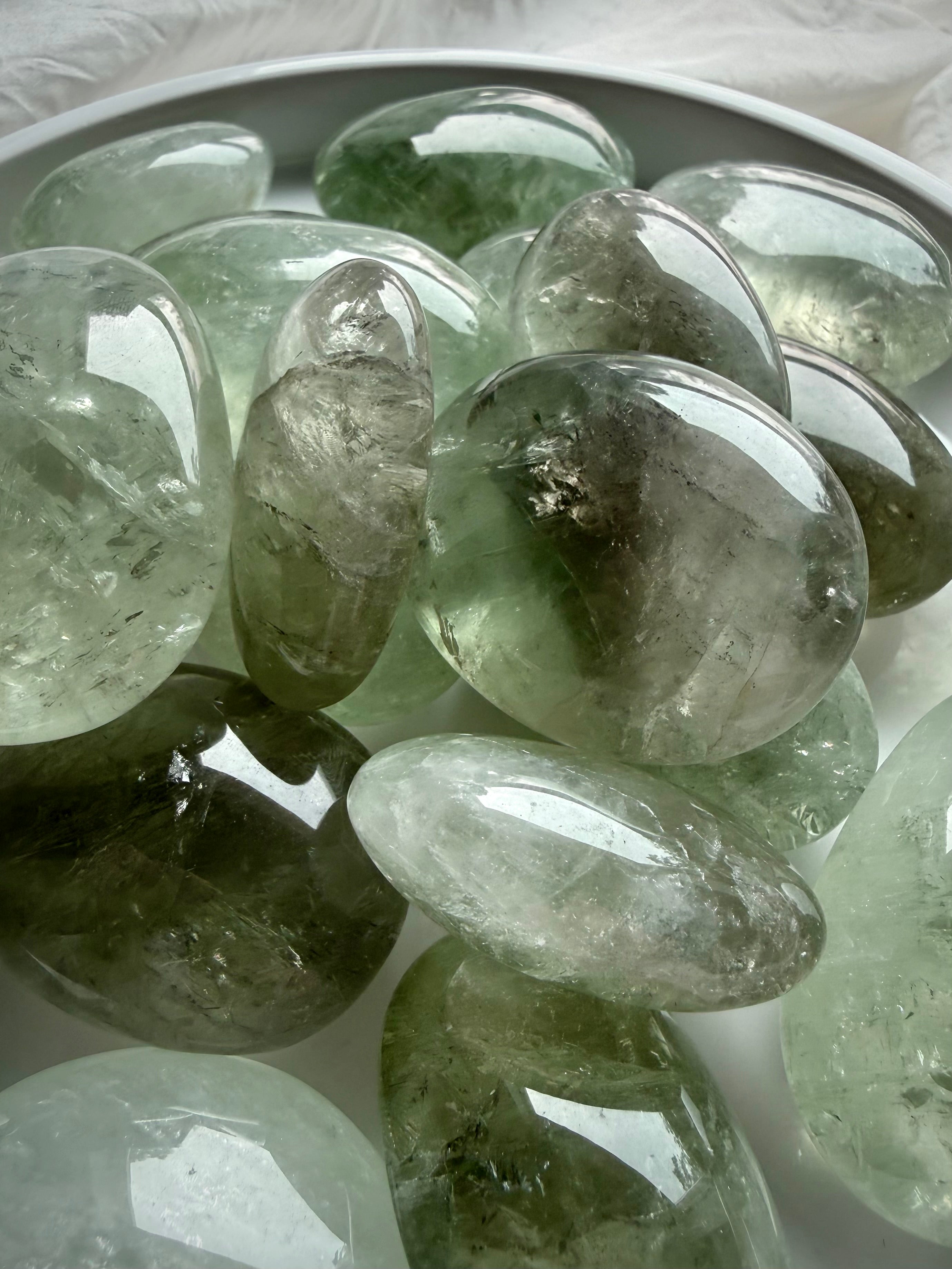 Close up of Prasiolite palm stones displaying translucent clarity and natural crystal patterns