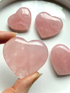 Rose Quartz palm hearts in multiple sizes with luminous pink color and natural variation in each crystal carving