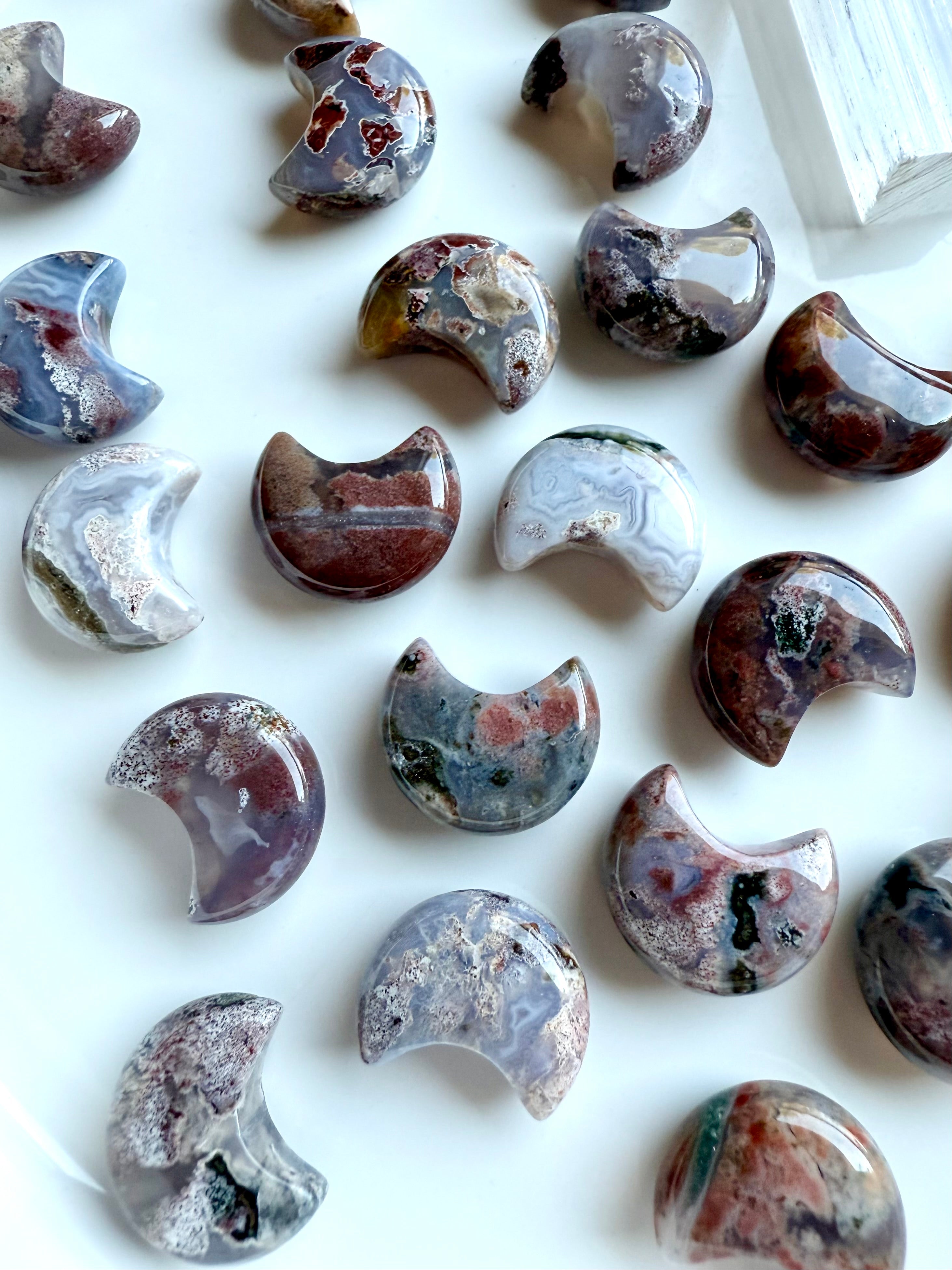 Group of mini Ocean Jasper crescent moon carvings, polished with swirling colors