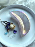 Opalescent Aura Rose Quartz crescent moon bowl on white dish with dried rose and mini crystal carvings