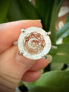 Close-up of Clear Quartz Crescent Moon Ring worn on finger with faceted gem and celestial etching set in sterling silver